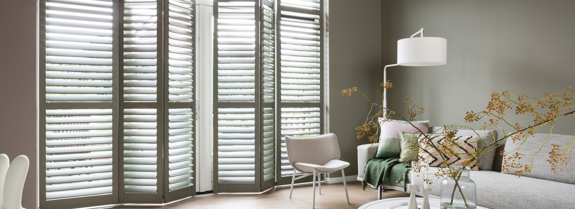 Sfeerfoto van woonkamer met houten shutters in kleur 7003 Moss Grey, op rails